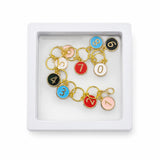 Colorful numbered knitting stitch markers from 0 to 9 with gold-tone rings and clear storage box