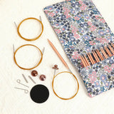 Complete circular knitting needle set arranged beside its floral storage pouch