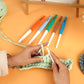 Large ergonomic crochet hook being used with chunky green yarn