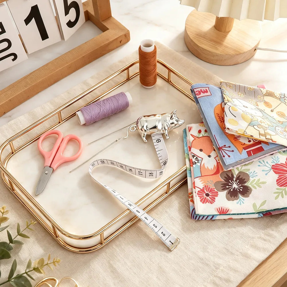 Pig-shaped silver tape measure arranged with fabric and sewing tools