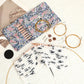 Rose gold interchangeable circular knitting needles in use with floral pouch and accessories nearby