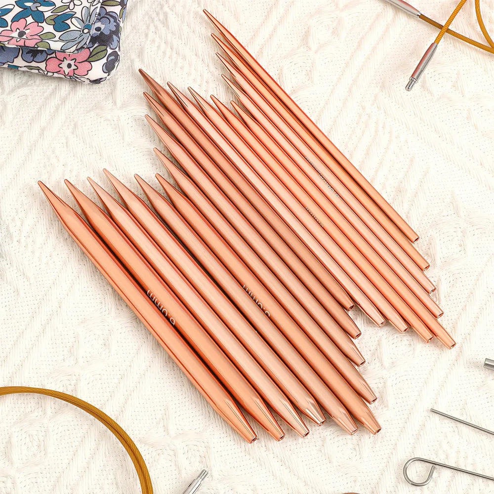 Close-up of nine pairs of rose gold interchangeable knitting needle tips