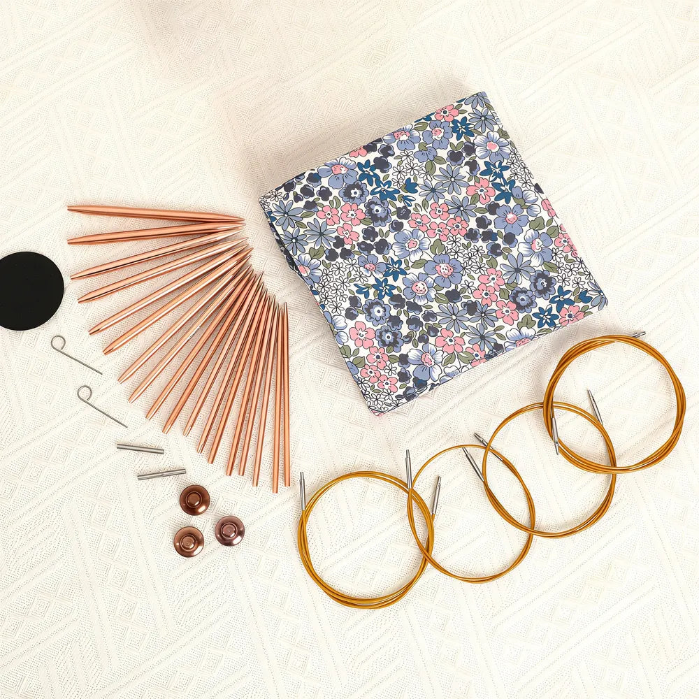 Nine pairs of rose gold needle tips with four cables and knitting accessories